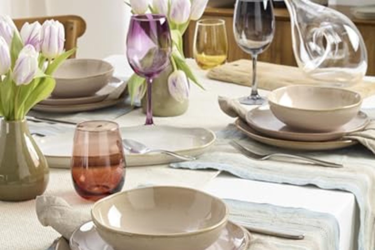 A spring table with tulips, bowls and wine glasses catching the light