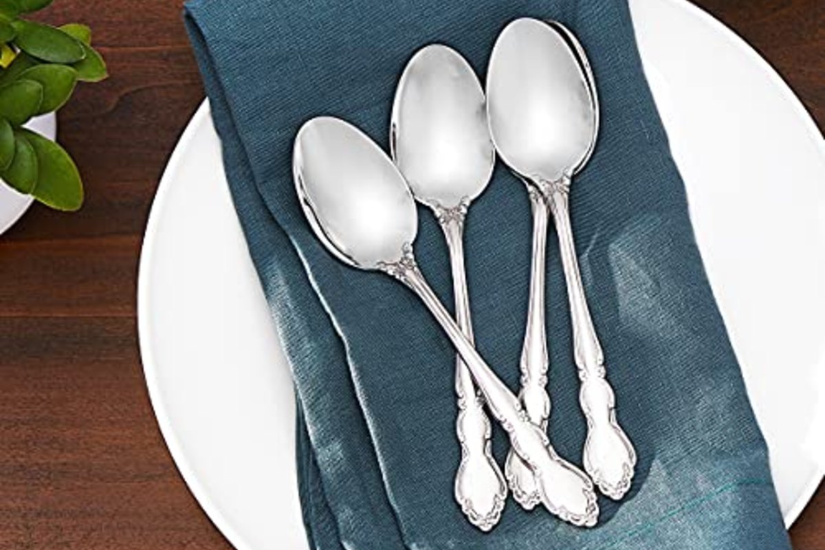 Four teaspoons fanned across a teal napkin on a white plate